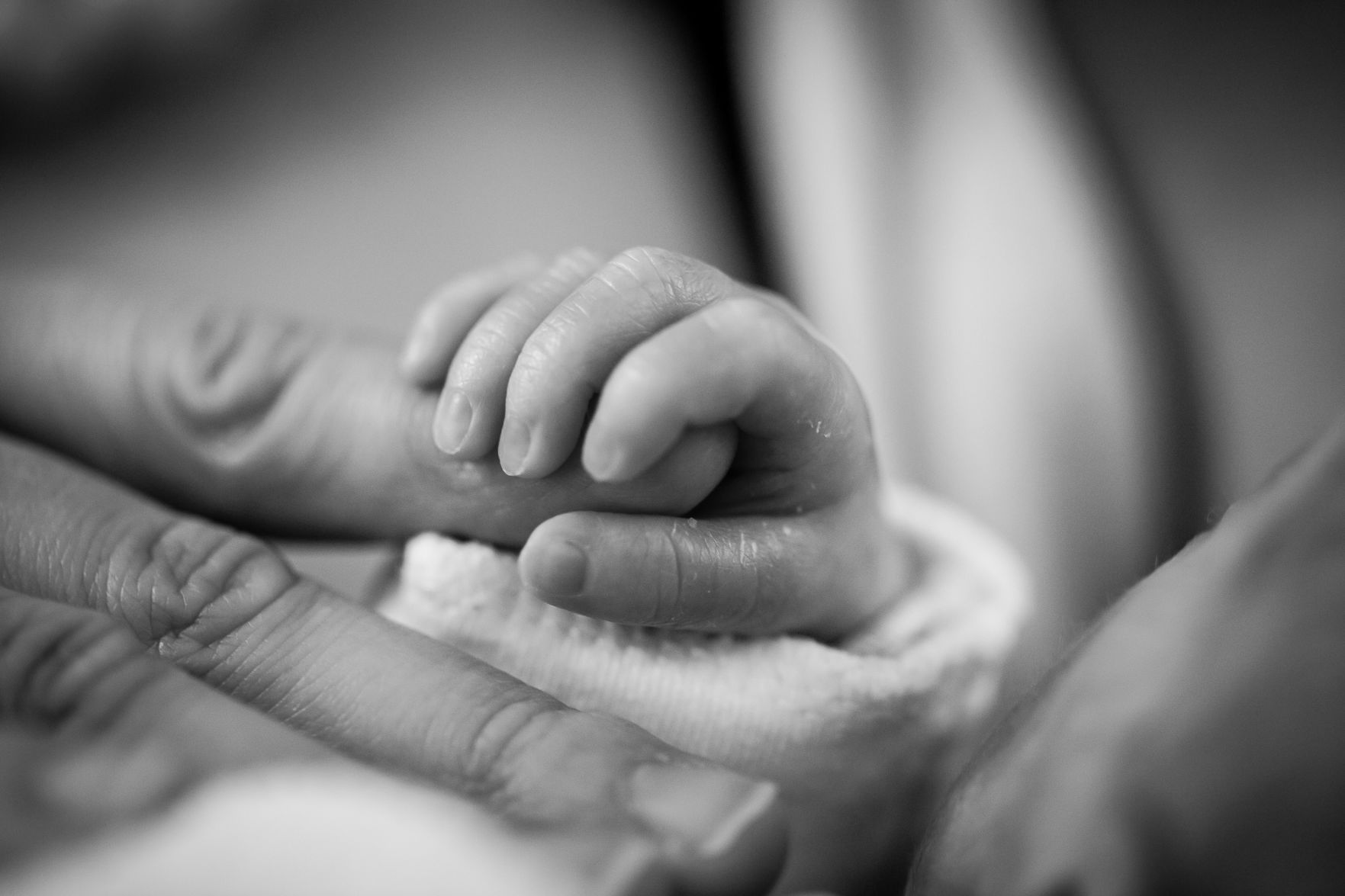 grayscale-photography-of-baby-holding-finger-208189.jpg
